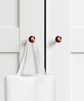 Dope Abstract Red And Black Cabinet Knobs Set 1.4 Inch Solid Beech Wood Drawer Pulls featuring red and black knobs on white cabinet.