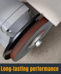 Close-up of a half inch by eighteen inch aluminum oxide sanding belt mounted on a sander for heavy duty woodworking and metal polishing.