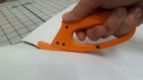 Close-up of Totally Rock Solid Bi Directional Safety Knife With Slick Retractable Blade and Ergonomic Handle in use cutting vinyl.