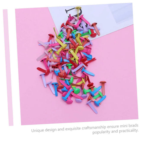 300Pcs Miniature Brads Round Fasteners in assorted colors on pink surface for crafts DIY projects scrapbooking card making