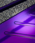 Close-up of Candy Purple Transparent Polyester Powder Coat finish on automotive metal part with deep blue tint and high gloss.