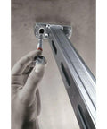 Hand installing Kwik Bolt TZ Carbon Steel Expansion Anchor One Half Inch By Seven Inch into ceiling bracket