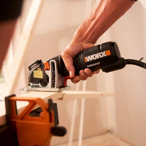 Hand using Compact Palm Saw With 3 Amp Motor And 3 3/8 Inch Blade on wood with clamp, showcasing ergonomic grip and lightweight design.