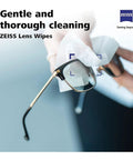 Zeiss Lens Wipes 120-pack; close-up of eyeglasses being wiped with a white wipe, Zeiss logo top-right.