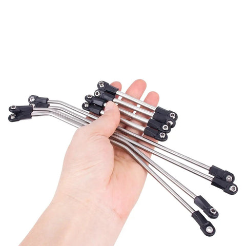 Hand holding link rods from One Tenth Scale Performance Carbon LCG Chassis Kit With Gearbox And Shock Absorbers For RC Crawler.