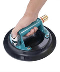 Hand holding 10 Inch Vacuum Suction Cup Lifter for Granite and Glass with Metal Handle and Brass Pump, durable rubber pad, close-up view