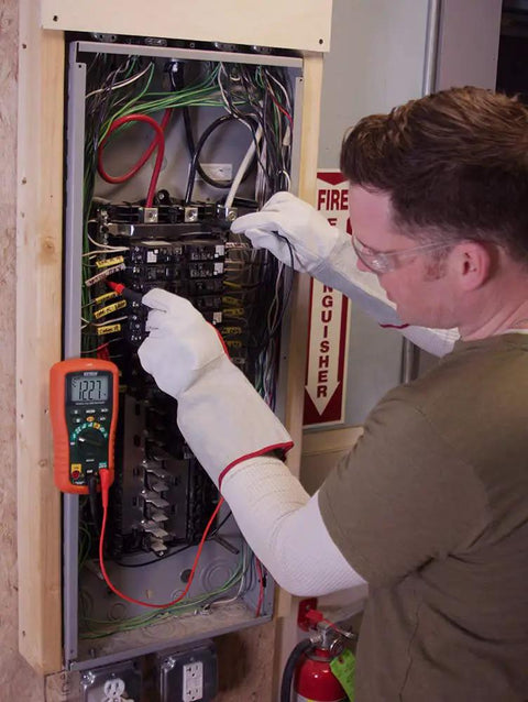 Technician using Datalogging Cat IV True RMS Multimeter With Bluetooth Connectivity at circuit panel for remote data logging.