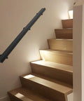 Kick Ass Heavy Duty Wall Mount Handrail In Matte Black Stainless Steel With Non Slip Grip For Modern Indoor Stairs installed on wooden stairs.