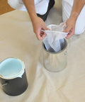 Person placing Regular Mesh Bag Strainers For 1 Gallon Pails Elastic Top 25 Pack 600 Micron White Filters over a paint can.