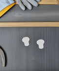 Thinking Process: white plastic skating bearing spacers for wheels, shown as small inserts on dark wood
