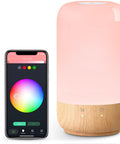 Smart Bedside Lamp With Alexa And Google Assistant, RGB Color Changing LED, 2700K-5700K Tunable White, Dimmable Night Light, Wood Grain Table Lamp, WiFi 2.4GHz Control From Anywhere, Hands Free Voice Or App Control next to smartphone app interface