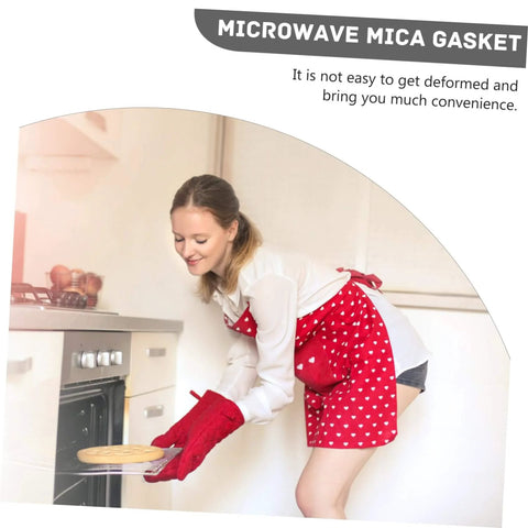 Woman using microwave wearing red apron with heart pattern near oven, demonstrating Ten Pieces Cuttable Mica Plates For Microwave Oven Heat Resistant Insulation And Cover Sheets A Must Have To Extend Oven Life And Boost Efficiency Durable Easy To Install Waveguide Mica Covers For Home Kitchen Use.