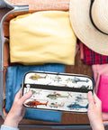 Foldable Travel Toiletry Bag For Women And Men, Water Resistant Dopp Kit with helicopter design in open suitcase with clothes