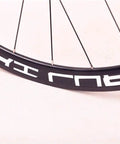 Close-up of Road Bike Wheelset 700C with carbon fiber hubs, dope double wall alloy rims, front CV brake, for training and competition.