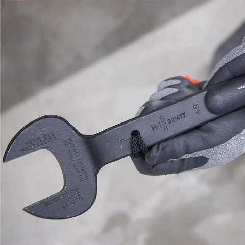 Close-up of Workhorse Construction Spud Wrench With Tether Hole Made In USA 1-1/4 Inch Opening held by gloved hand.