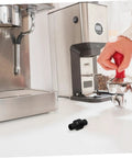 Barista Grade Heatproof Rubber Steam Wand Sleeve for espresso machines on counter near coffee maker and tamper.