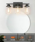 Slick Black 3 Light Vanity Light Fixtures Over Mirror With Clear Glass Shades in modern bathroom setting