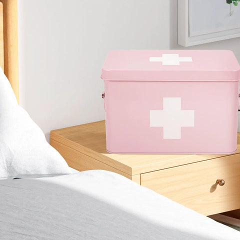 Pink Vintage 13 Inch Metal First Aid Box Organizer With Removable Tray, Adjustable Dividers, And White Cross Logo on nightstand