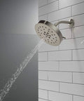 H2Okinetic 4-Setting UltraSoak Shower Head in Stainless Steel - Drenching Rainlike Spray With Water Sculpting Tech on tiled wall.
