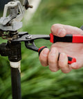 Person using 6.5 Inch Slip Joint Pliers with Groove Joint Function on a pipe valve, showcasing ergonomic grip and heavy duty use.