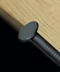 Close-up of a Bright Steel Framing Nail 14 Gauge Half Inch Wood Fastener embedded in wood surface, ideal for carpentry.