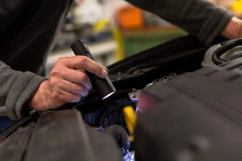 Person using Rugged Aluminum Flashlight With 450 Lumens And Flood To Spot Focus Built For Pocket EDC And Outdoor Adventures in car repair