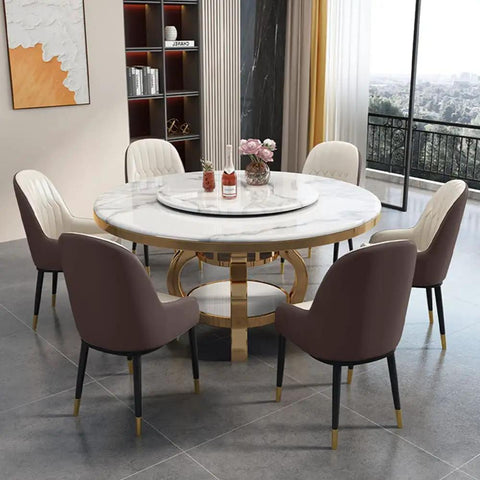 Kickback Ready Round Marble Dining Table Built For Epic Weekend Hangouts Featuring A Smooth White Spinning Lazy Susan And Bold Gold Stainless Steel Base Stretching Fifty Nine Inches Wide with six chairs.