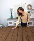Woman applying Smooth Operator Liquid Wood Gel Stain on a round wooden table in deep dark oak finish.