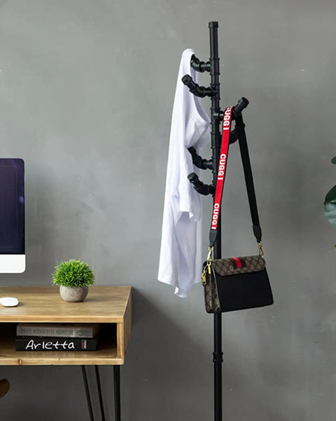 Industrial decor with black metal rack, shirt, and bag in modern office setting