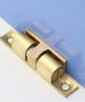 Double Ball Cabinet Door Catch With Adjustable Tension Roller Latch in copper, mounted on blue and white surface