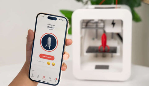 Smartphone showing rocket print on app, Beginner Friendly 3D Printer For Kids With Easy Setup And Safe Design in the background