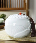 Premium Ceramic Sugar Jar And Airtight Tea Canister Keeps Coffee Stash Crisp, white ceramic jar with a textured lid and tassel.