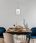 Totally Sleek Modern Mini Pendant Light In Brushed Nickel With Frosted Glass Shade hanging over dining table.