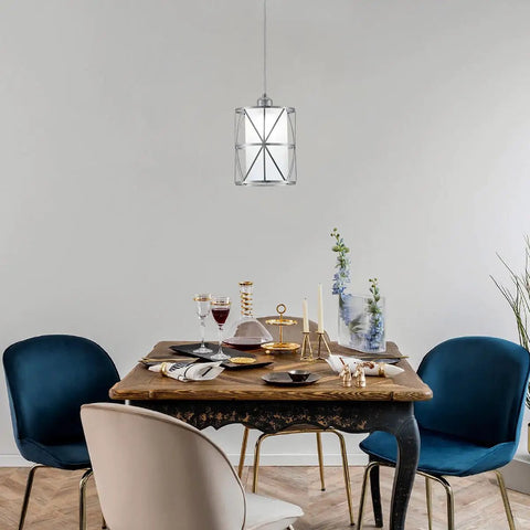 Totally Sleek Modern Mini Pendant Light In Brushed Nickel With Frosted Glass Shade hanging over dining table.