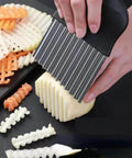 Crinkle cutter knife, stainless steel, used to slice potatoes into crinkle-cut fries (close-up).