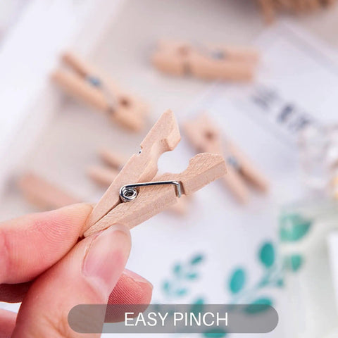 Top Shelf 100 Piece Mini Wooden Clothespins With Handy Storage Bag Dead Serious Grip Birch Hardwood Clips shown in hand with easy pinch feature.