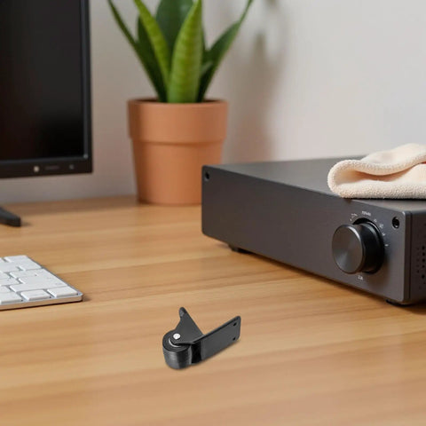 Heavy Duty Fixed Speaker Caster Wheels With L Bracket Mount on a desk near a monitor and plant, showcasing solid black metal design.
