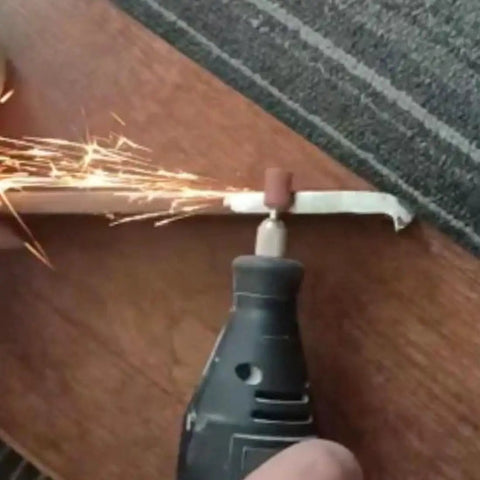 Using Assorted 100 Piece Grinding Stones Set With One Eighth Inch Shank For Rotary Tools to grind metal, sparks visible