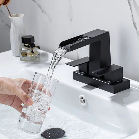 4 Inch Centerset Waterfall Bathroom Faucet With Two Handles, 3 Hole Basin Setup, Pop Up Drain With Overflow in use pouring water into a glass