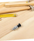 Rock Solid Stainless Steel Spring Plunger With Integrated Reset Mechanism And Precision Fine Thread lying on wood with tools.
