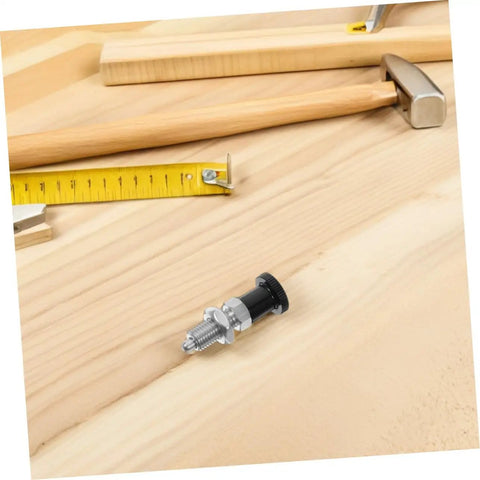 Rock Solid Stainless Steel Spring Plunger With Integrated Reset Mechanism And Precision Fine Thread lying on wood with tools.