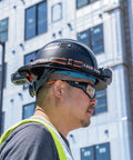 Man wearing hard hat with rechargeable portable cooling turbo fan, 3-speed, dual-mount strap, adjustable vent, long battery life
