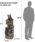 40.16 Inch High Five Tier Outdoor Bear Water Fountain With Two Black Bears Climbing A Tree For Garden Patio Yard Deck Farmhouse Exterior Chill Vibe Relaxation Resin Water Feature next to human silhouette for size comparison.