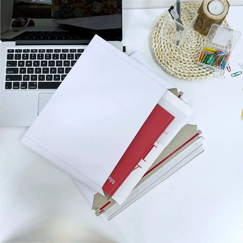 30 Pack White Rigid Mailers 12.5 By 9.45 Inches Self-Adhesive Seal Flat Cardboard Mailers next to a laptop on a desk
