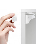 Person holding part of Magnetic Cabinet Locks For Baby Proofing Easy Install Adhesive Latches for Cabinets and Drawers, showing installation