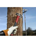 Absolute Beast Heavy Duty 4In1 Lineman Hammer 36 Oz Strike Built Different For Electricians And Job Site Pros Tough As Nails With Grippy Handle hitting a wooden pole.