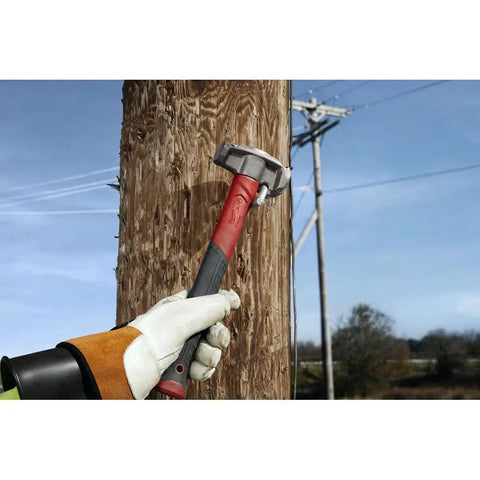 Absolute Beast Heavy Duty 4In1 Lineman Hammer 36 Oz Strike Built Different For Electricians And Job Site Pros Tough As Nails With Grippy Handle hitting a wooden pole.