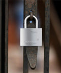70mm Heavy Duty Beefy Padlock With Waterproof Seal For Indoor Outdoor Use, locked on a metal gate, made of alloy steel with brass cylinder