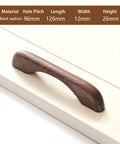 Two Solid Wood Dark Walnut Cabinet Pulls 126mm Overall Length 96mm Center to Center Mounting 12mm Width on cream surface