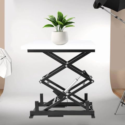 Heavy Duty Electric Scissor Lift Table Rises Smooth With Hydraulic Pump For Factory Work And Warehouse Lifting Up To 140 Pounds Of Steel Goods Or Equipment Effortlessly Today with plant on top.
